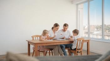 Parents avec leurs deux enfants assis à la table du salon, illustrant l’allocation familiale 2 enfants et la gestion du budget familial.
